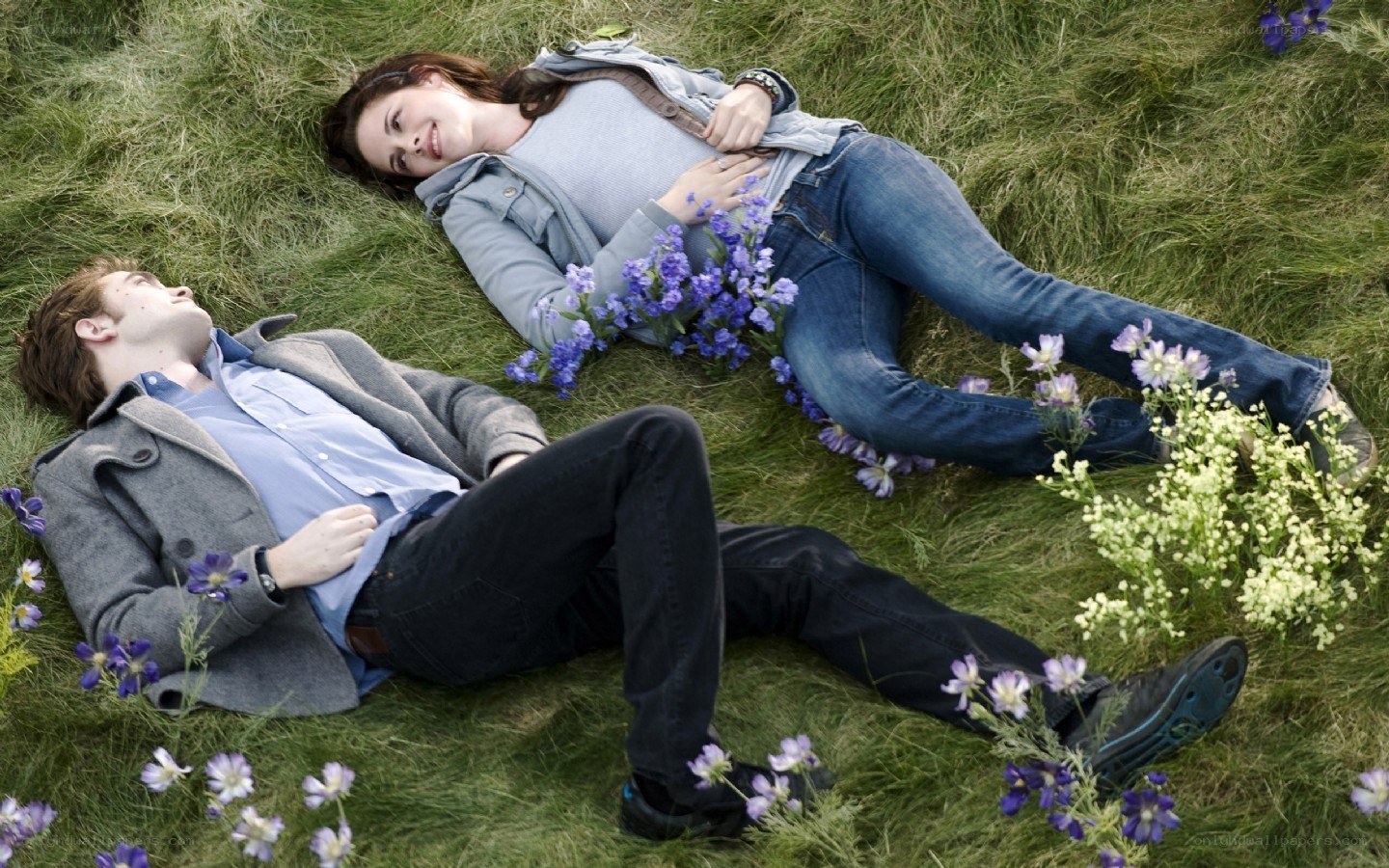 couple lying in grass with flowers