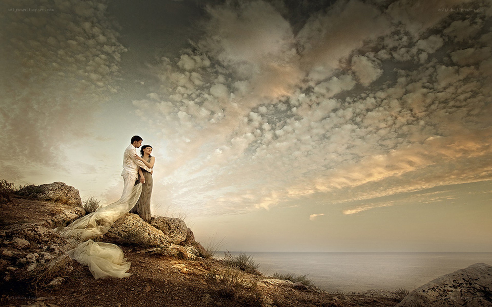 Couple on a cliff at sunset