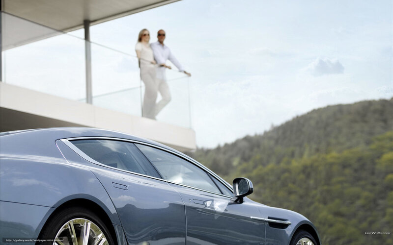 Couple on balcony with luxury car
