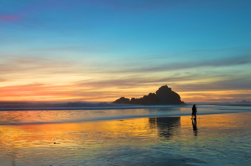 Couple on Beach at Sunset — Blue, Serene, Photograph, Silhouette, Rock Formation