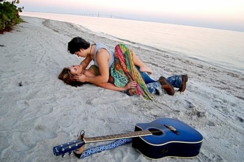 Couple on beach with guitar