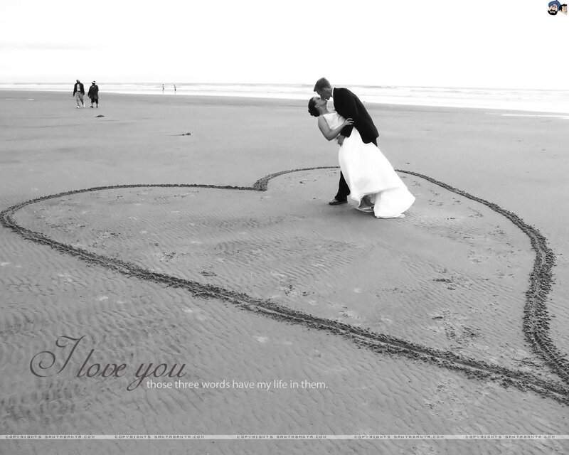 Couple on beach with heart drawing