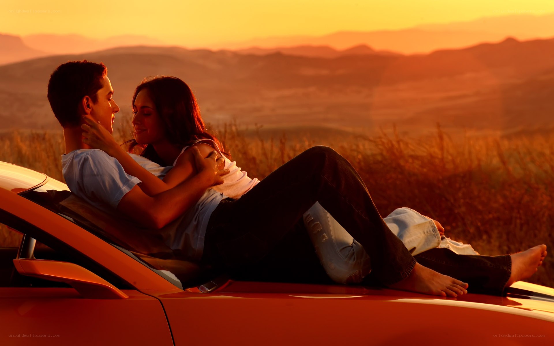 Couple on car at sunset
