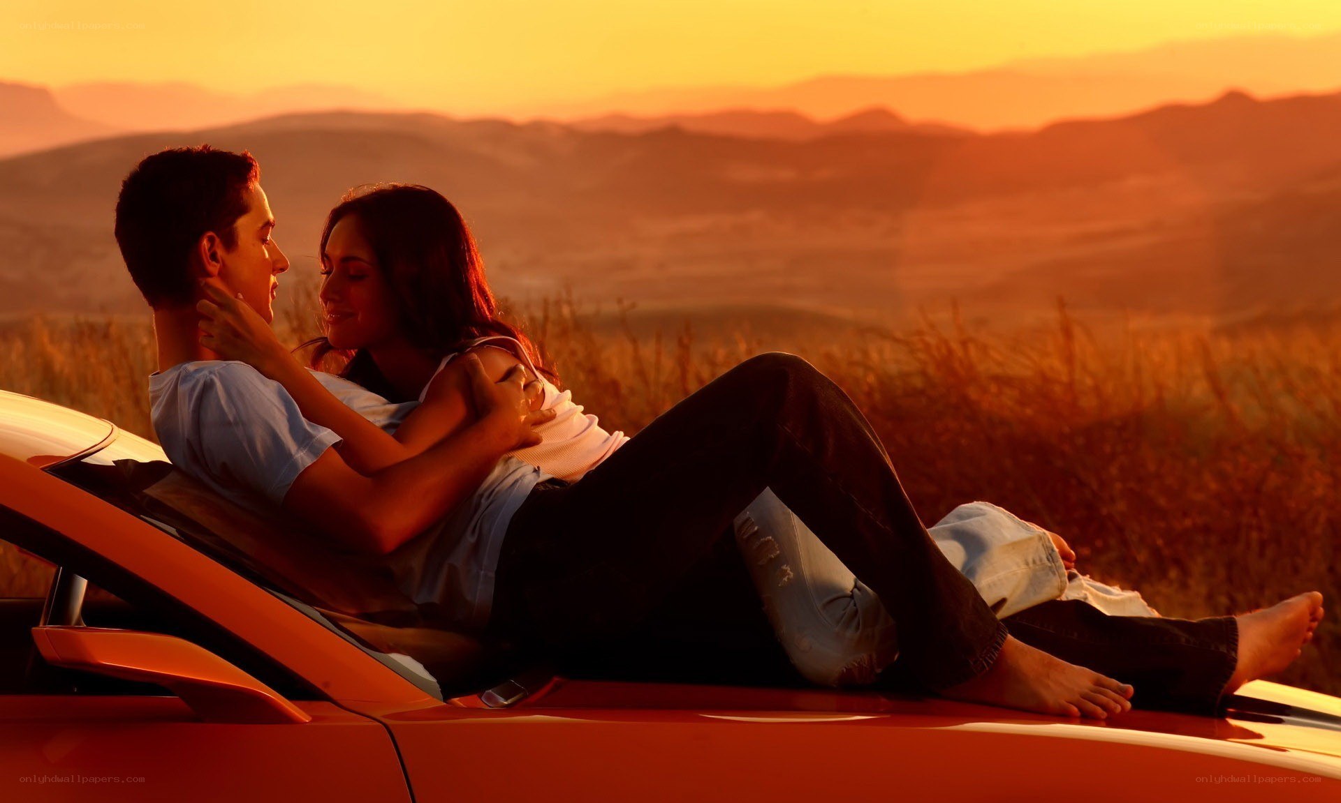 Couple on car at sunset