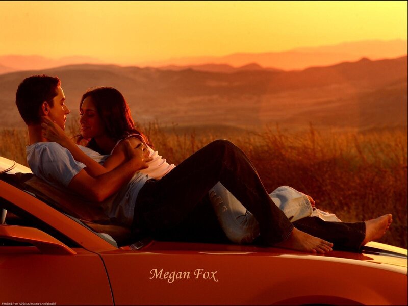 Couple on car at sunset