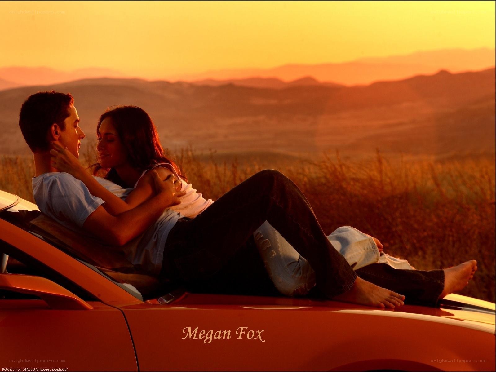 Couple on car at sunset