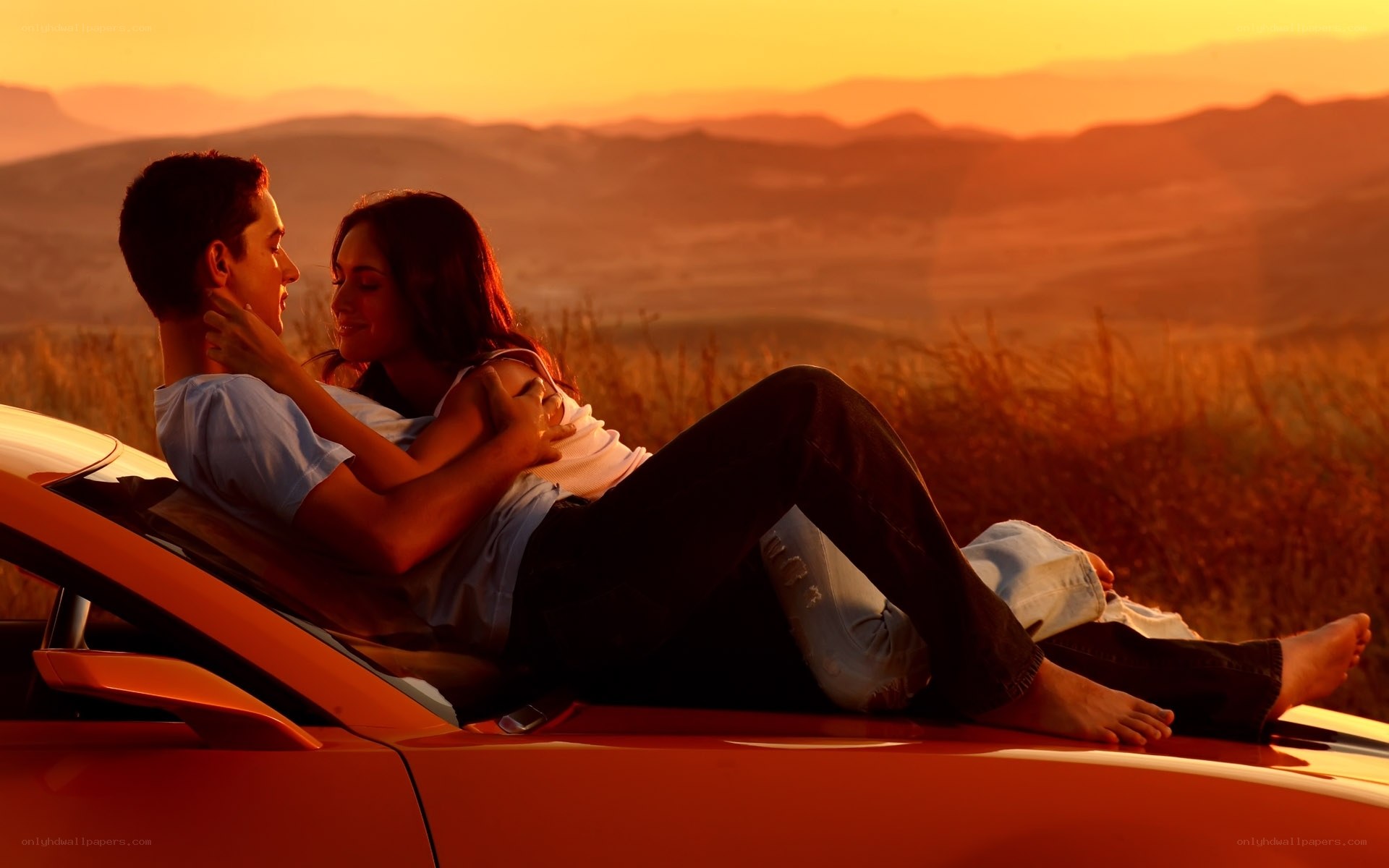Couple on car at sunset