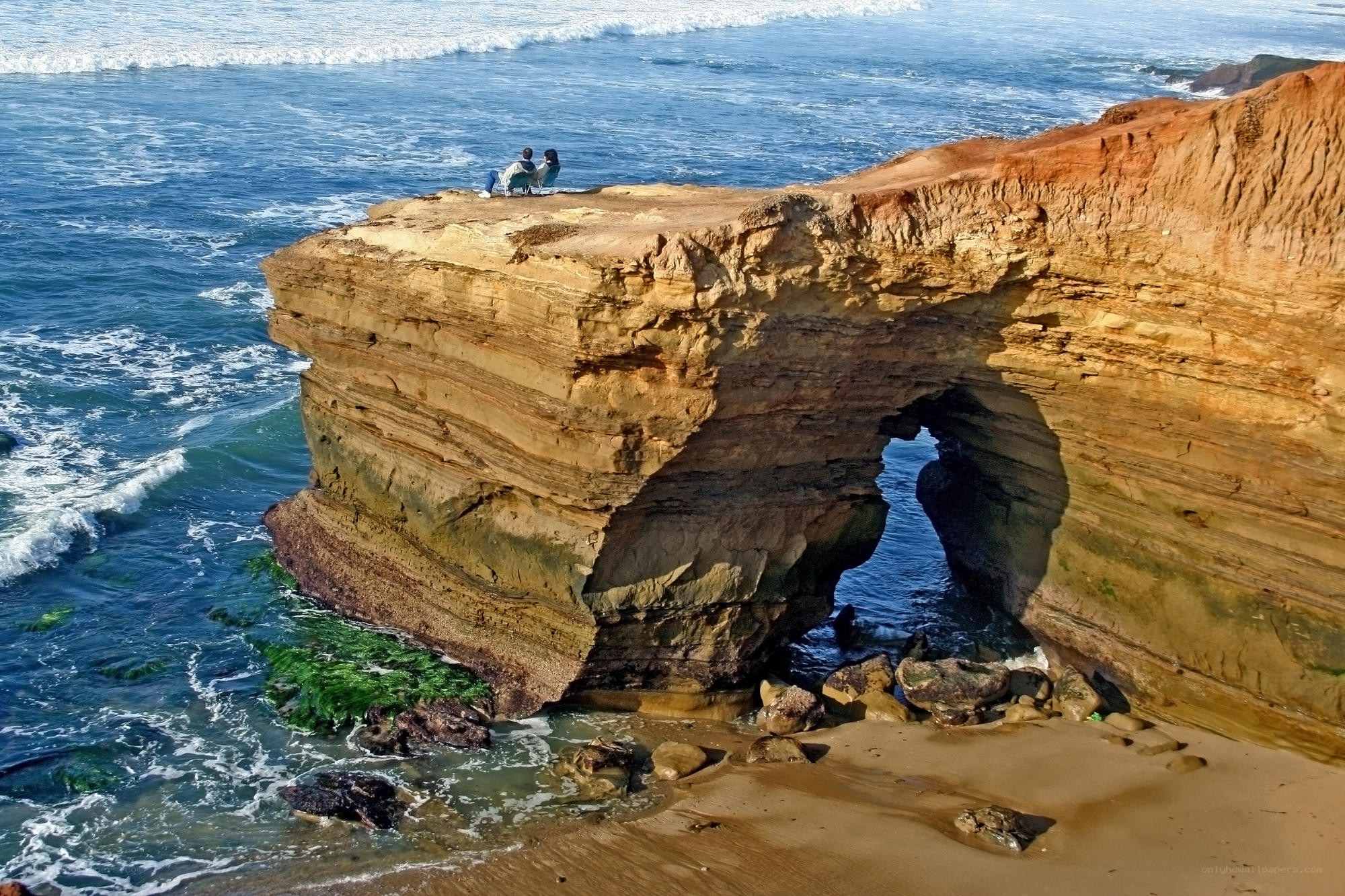 Couple on coastal cliff arch