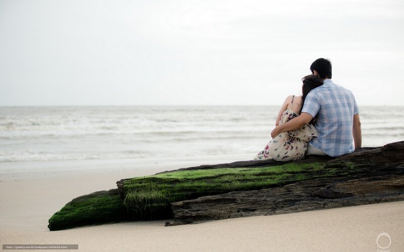 Couple on driftwood at beach
