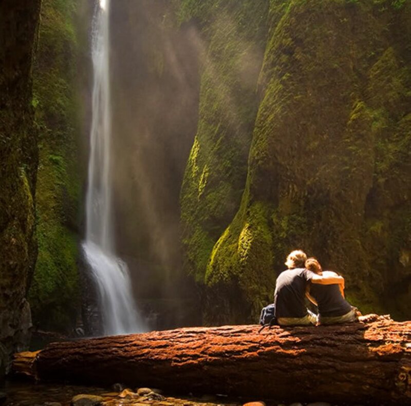 Couple on Log by Waterfall