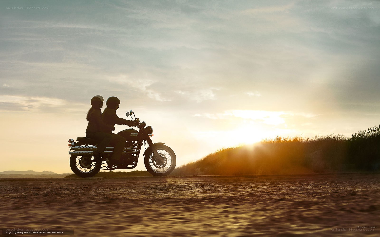 Couple on motorcycle at sunset