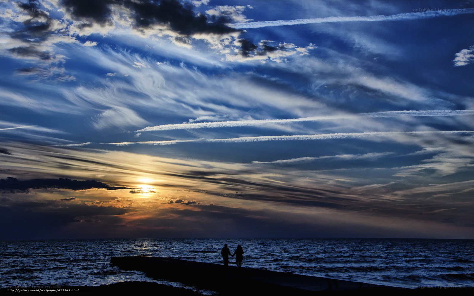 Couple on pier at sunset