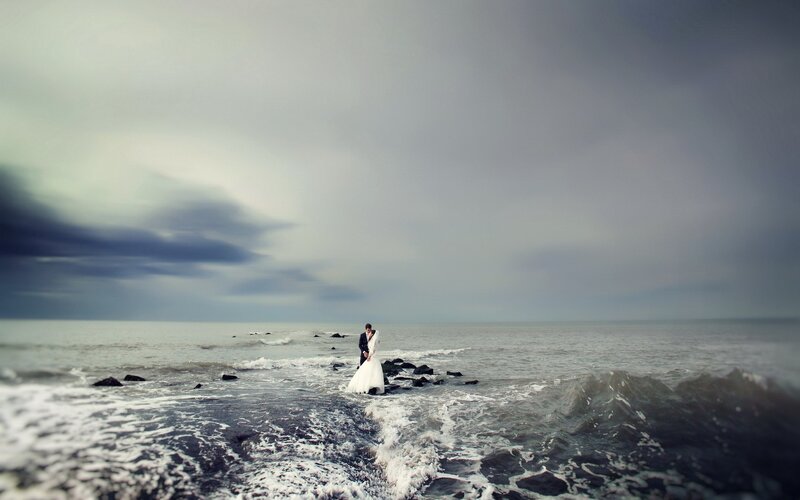 Couple on rocky beach at sunset