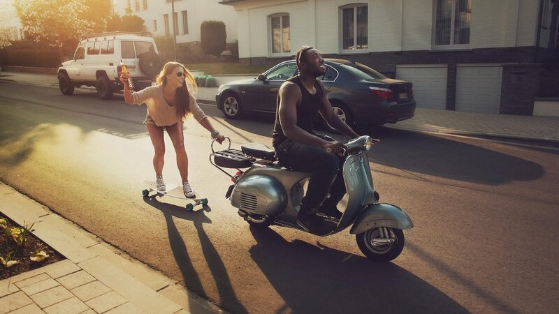 Couple on scooter and skateboard