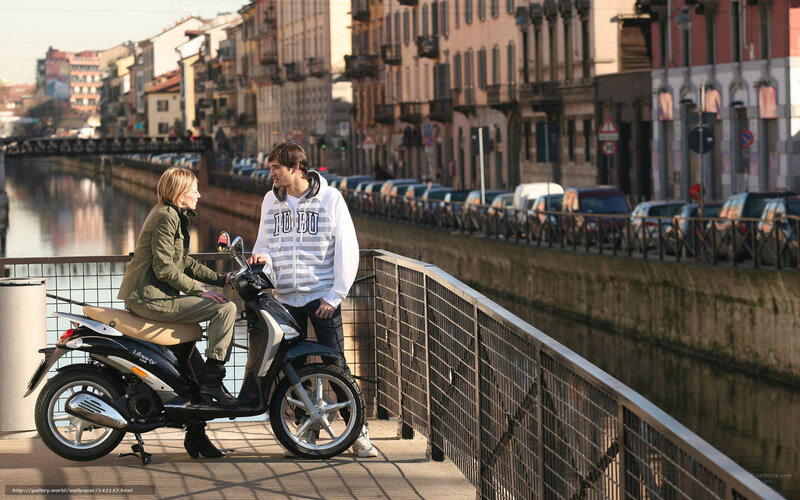 Couple on scooter by canal