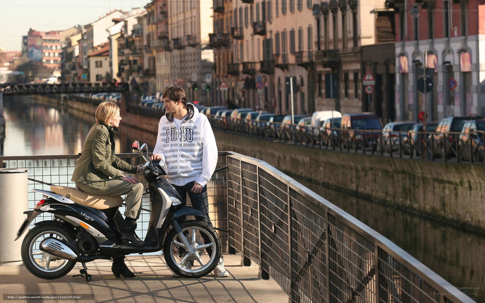 Couple on scooter by canal