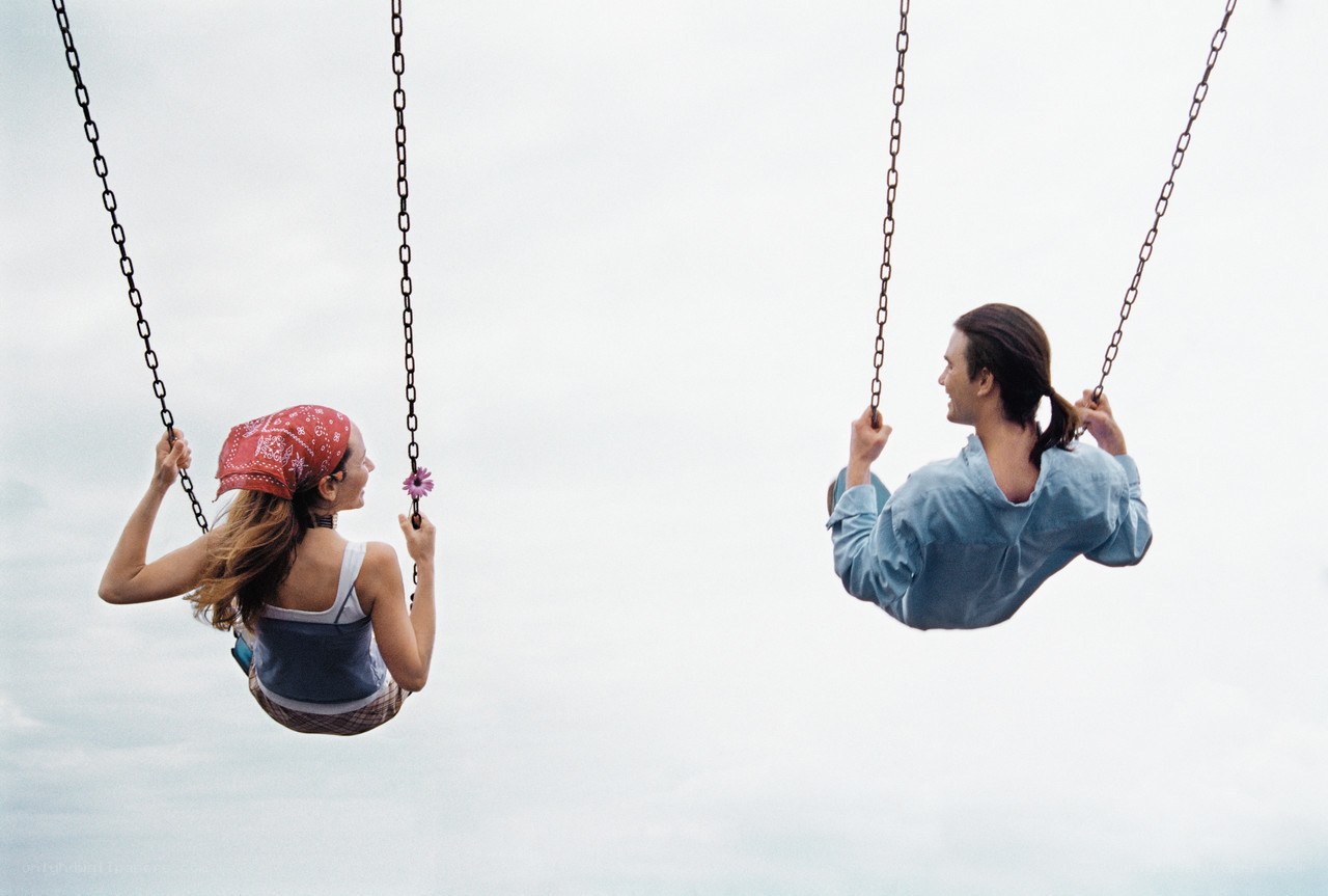 Couple on swings facing each other