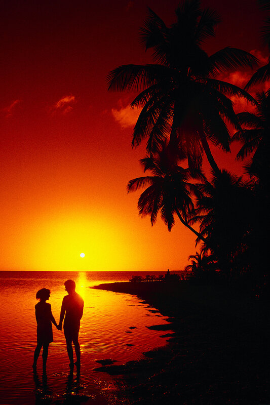 Couple on tropical beach at sunset