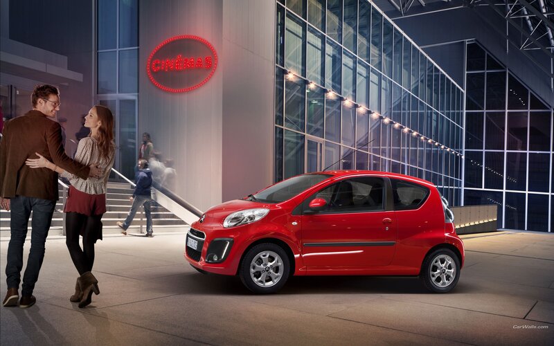 Couple outside cinema with red car