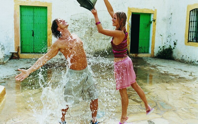 Couple playing with water in courtyard