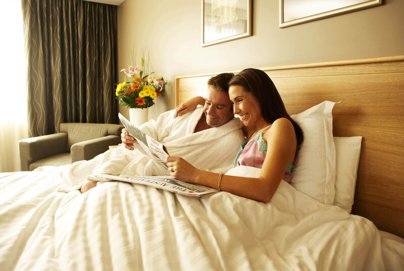 Couple reading newspaper in bed