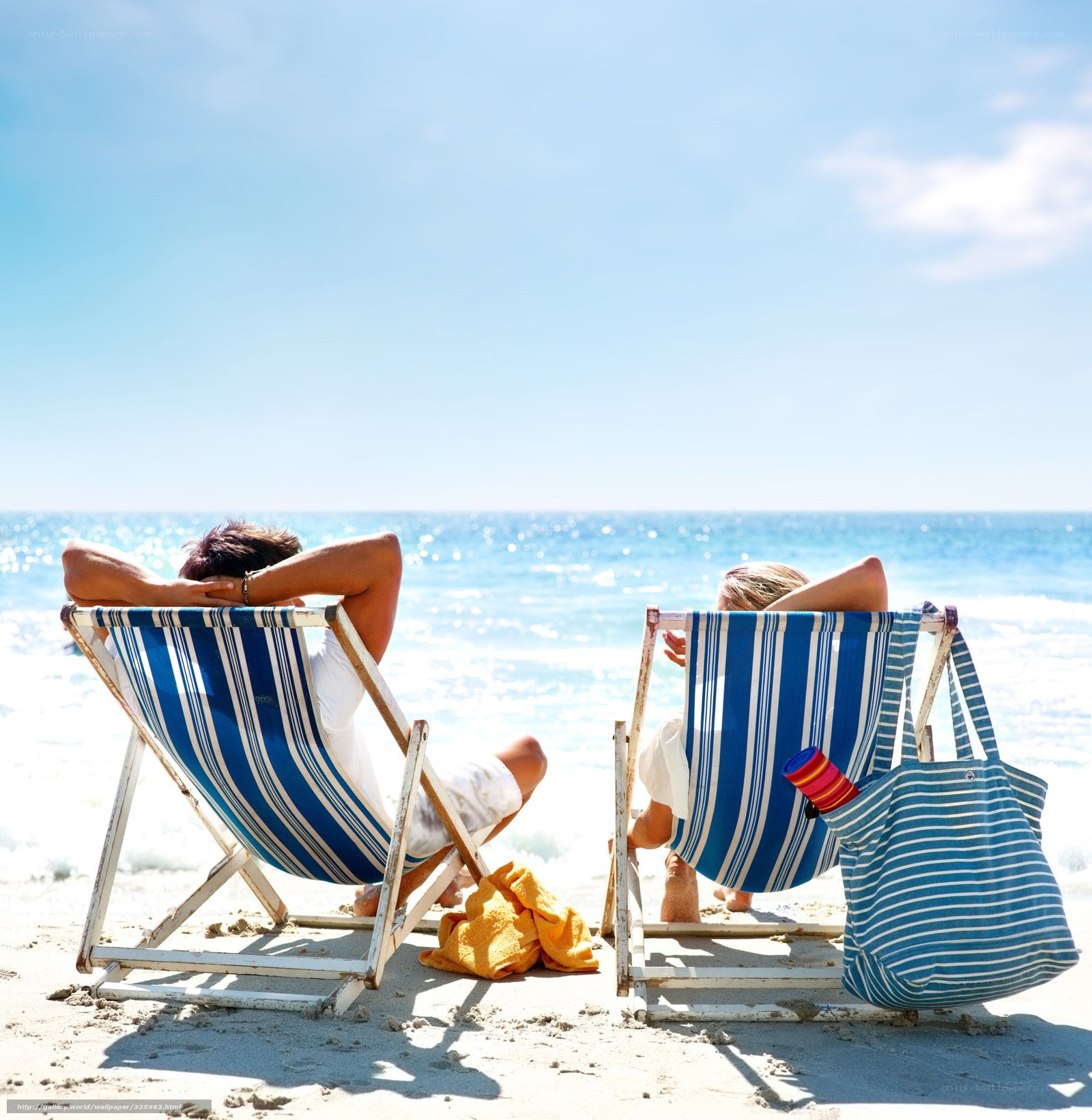 Couple relaxing on beach chairs