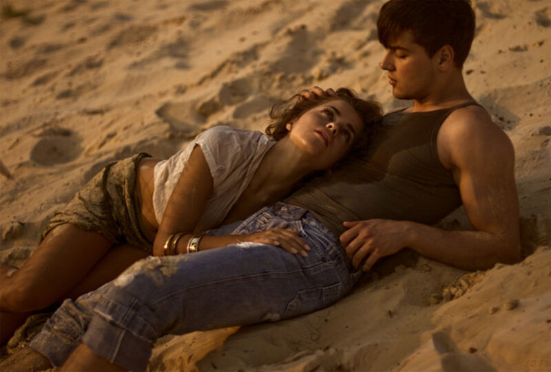 couple resting on sandy beach