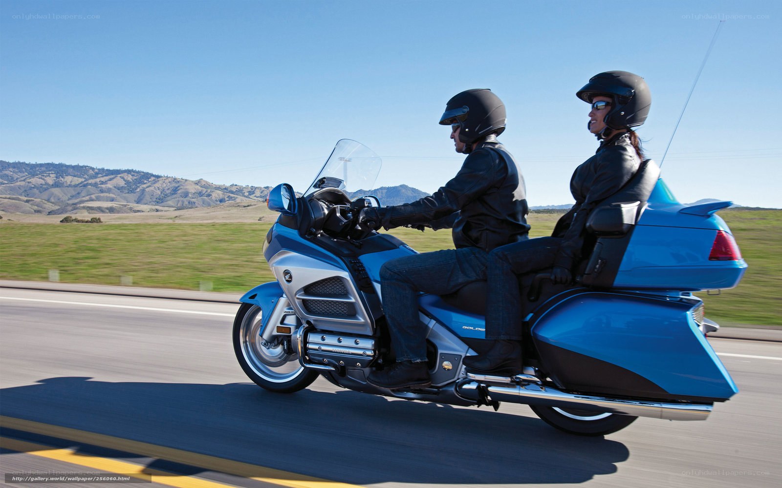 Couple riding blue touring motorcycle