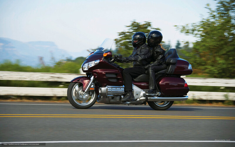 Couple riding maroon motorcycle