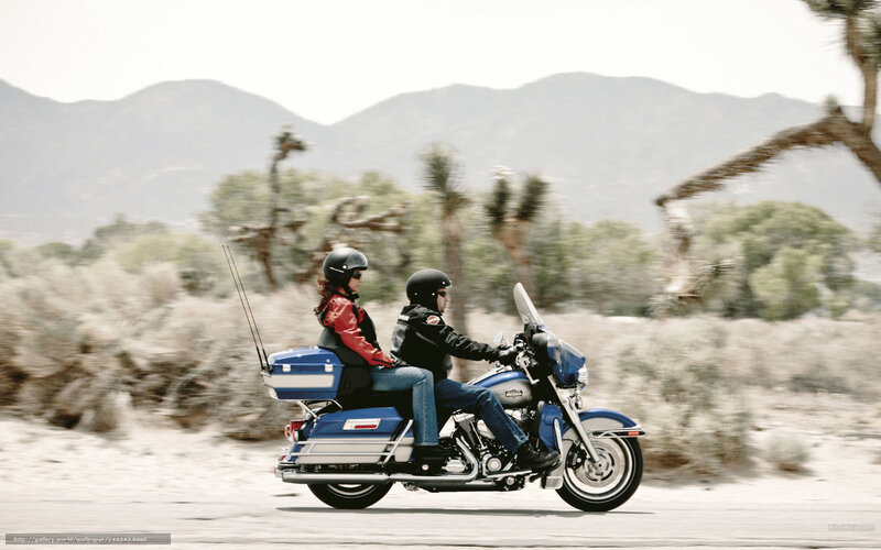 Couple riding motorcycle in desert