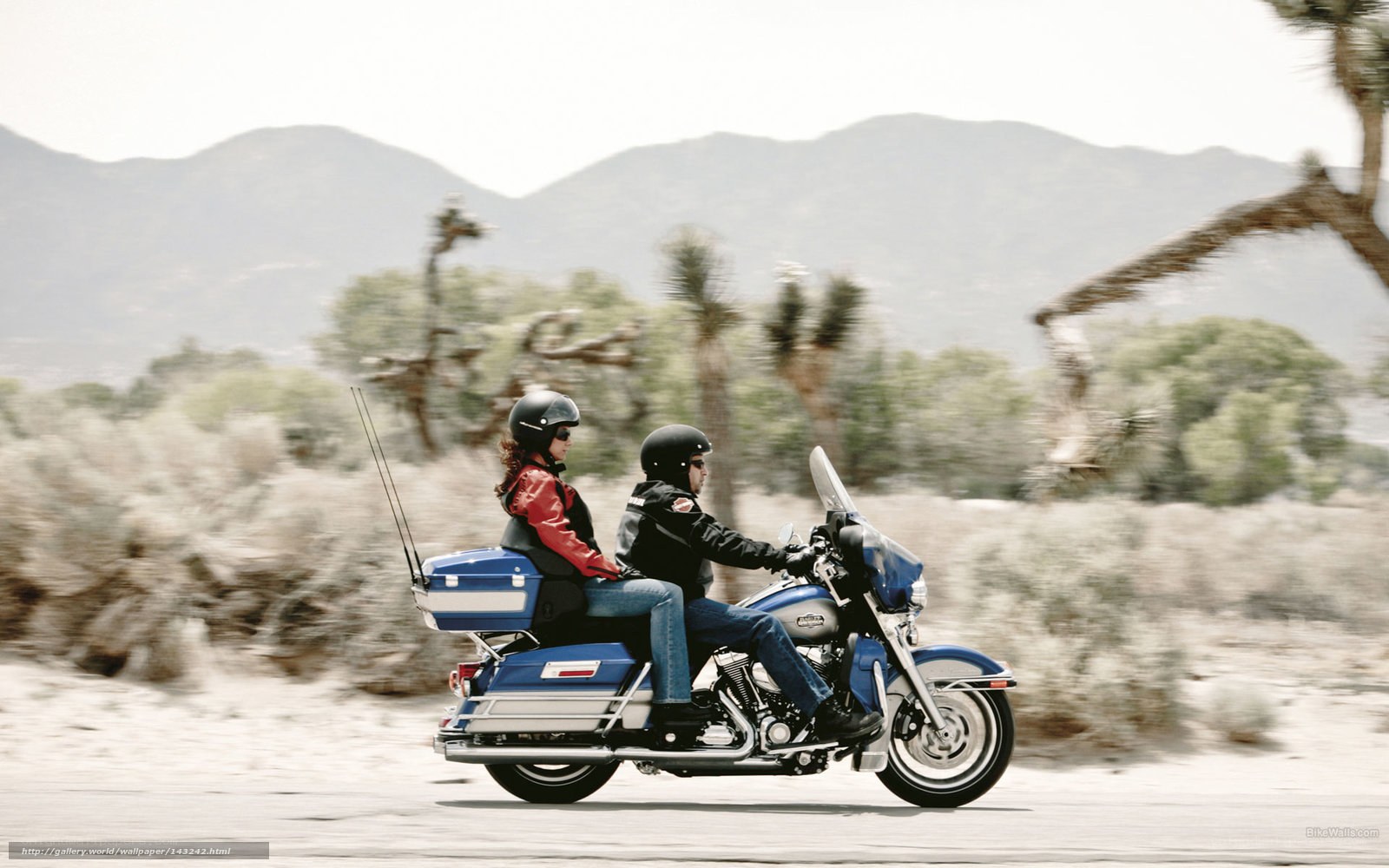 Couple riding motorcycle in desert