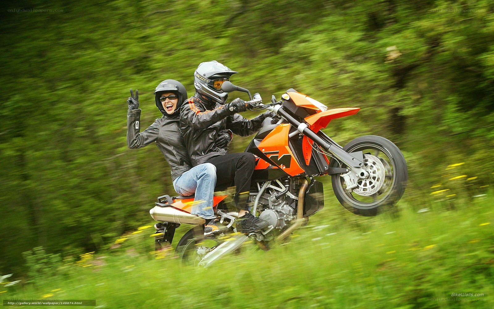 Couple riding motorcycle in forest