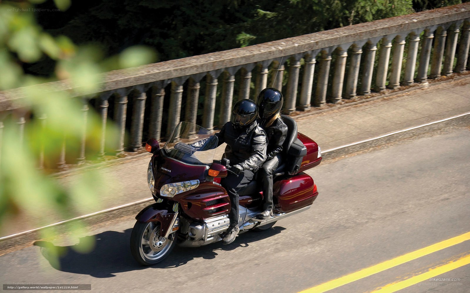 Couple riding motorcycle on bridge