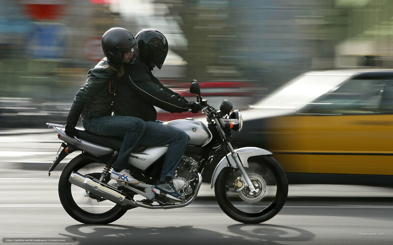 Couple riding motorcycle on city street