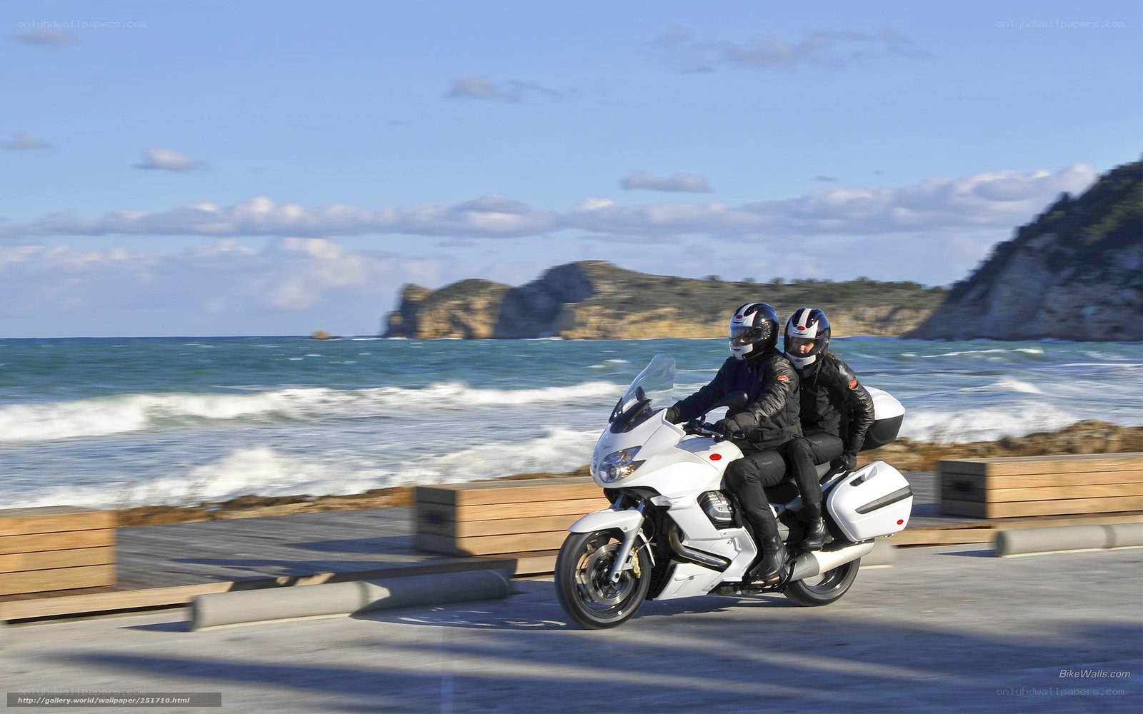 Couple riding motorcycle on coast