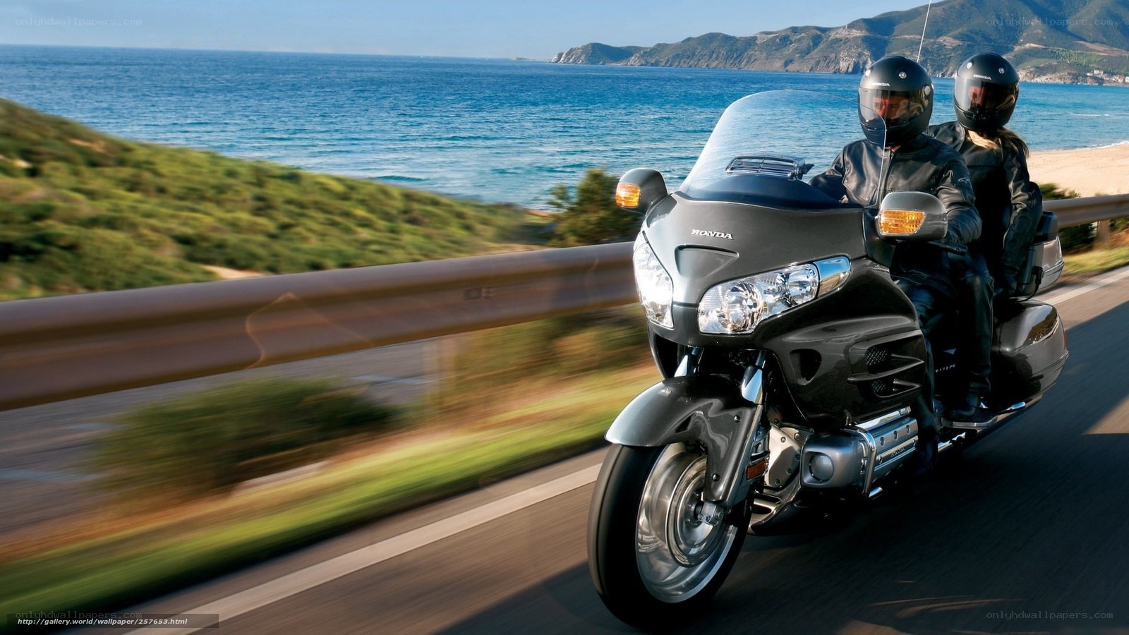 Couple riding motorcycle on coastal road