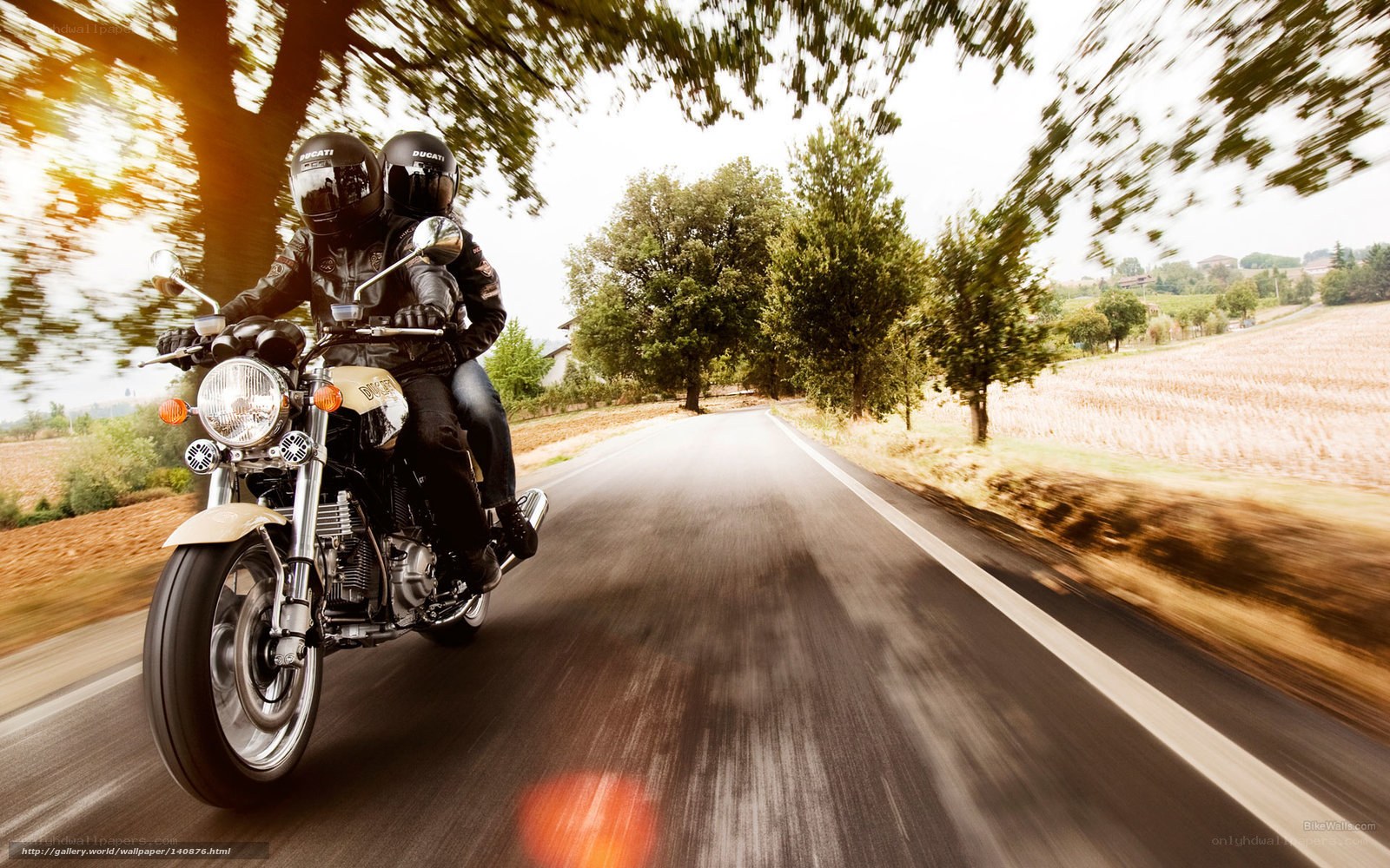Couple riding motorcycle on country road