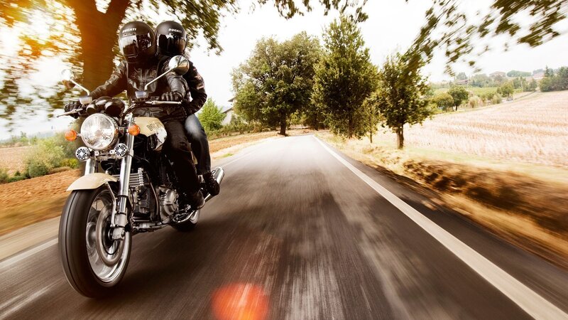 Couple riding motorcycle on country road