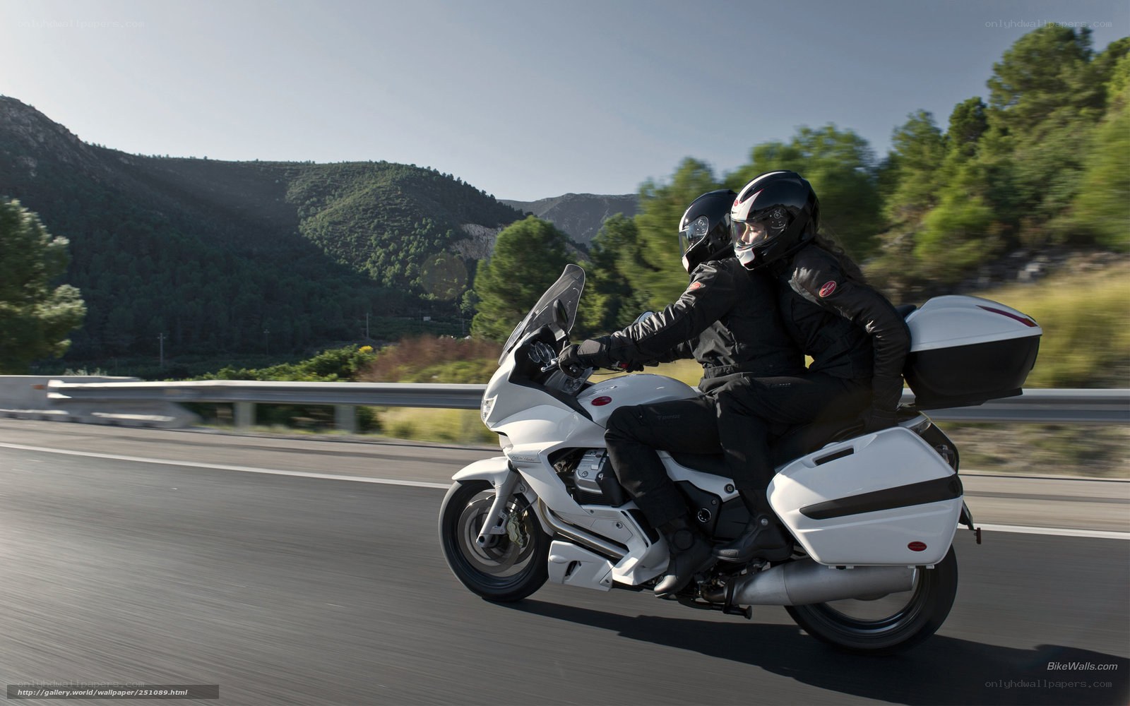 Couple riding motorcycle on highway