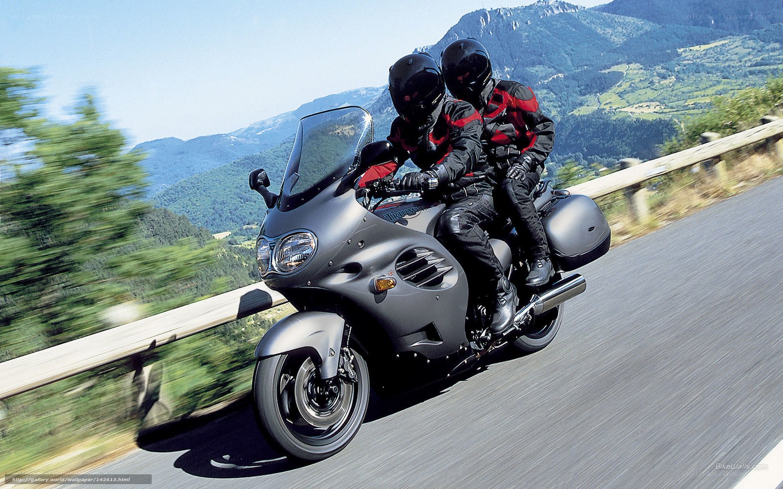 Couple riding motorcycle on mountain road