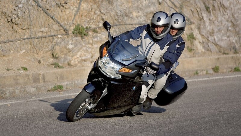 Couple riding motorcycle on road
