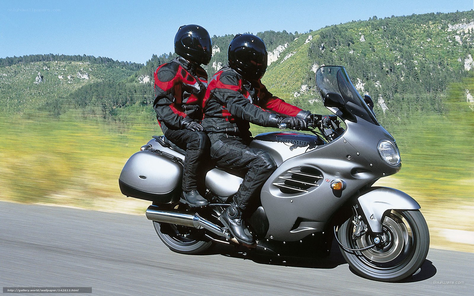Couple riding motorcycle on road
