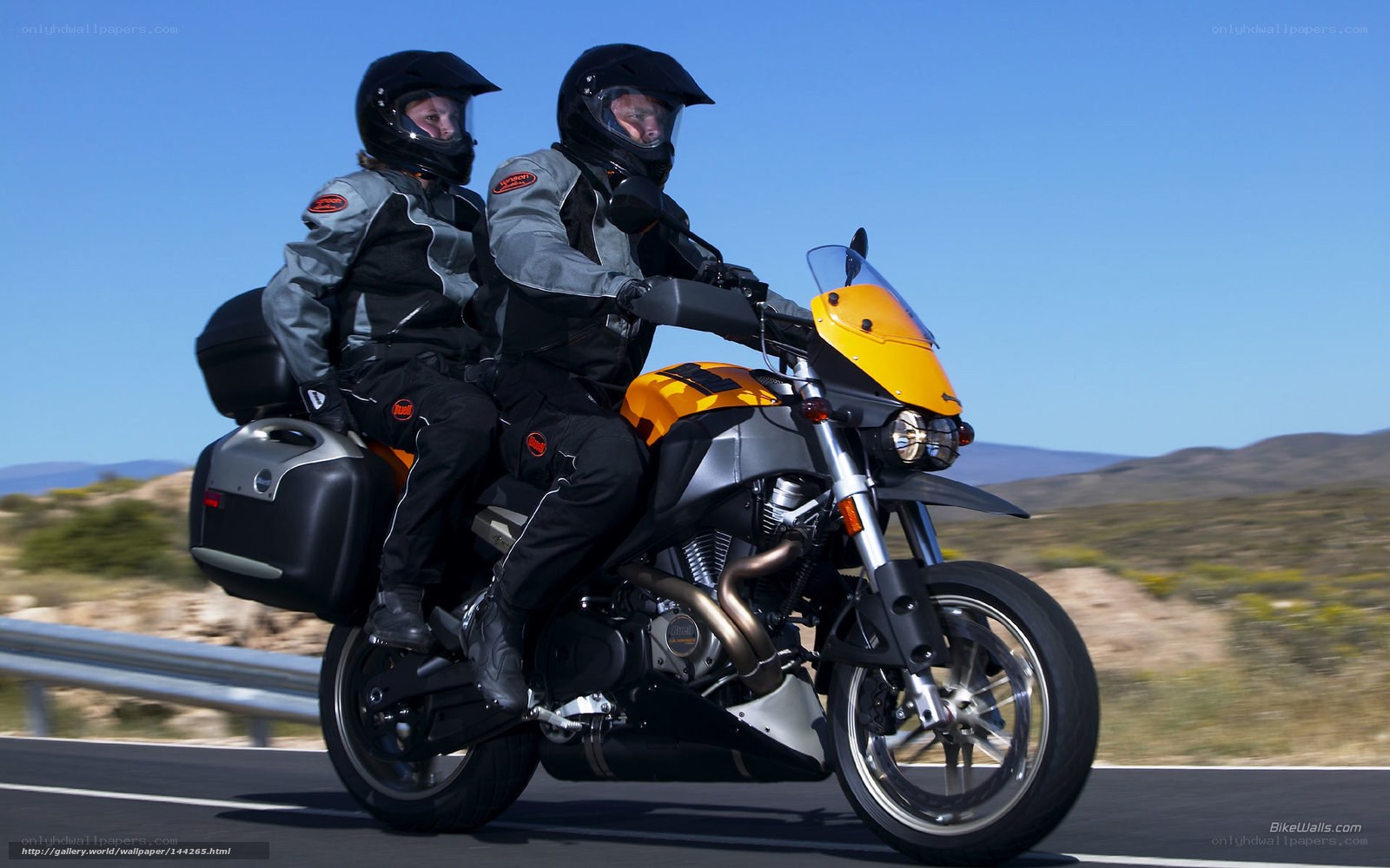 Couple riding motorcycle on road