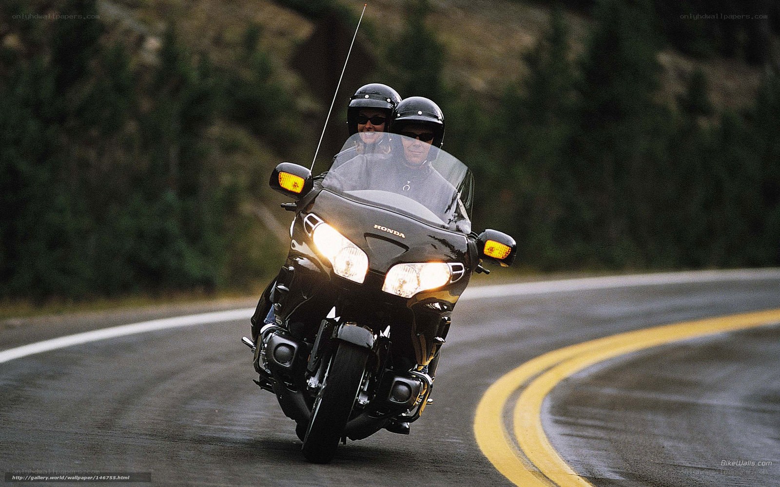 Couple riding motorcycle on road