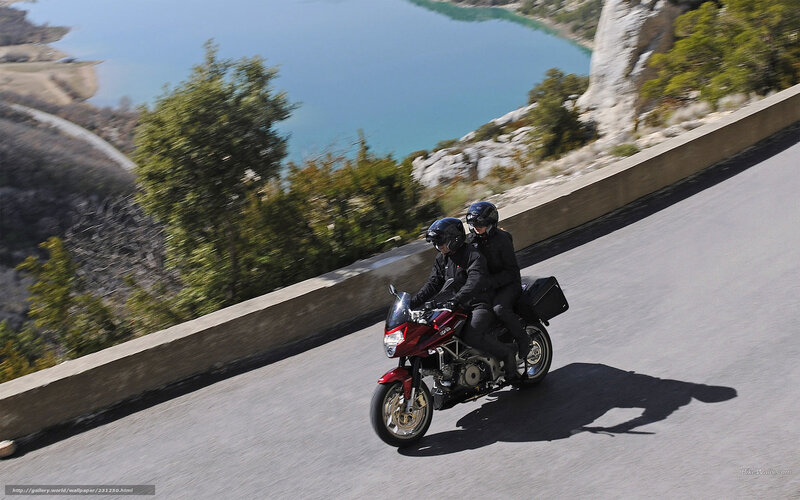 Couple riding motorcycle on scenic road