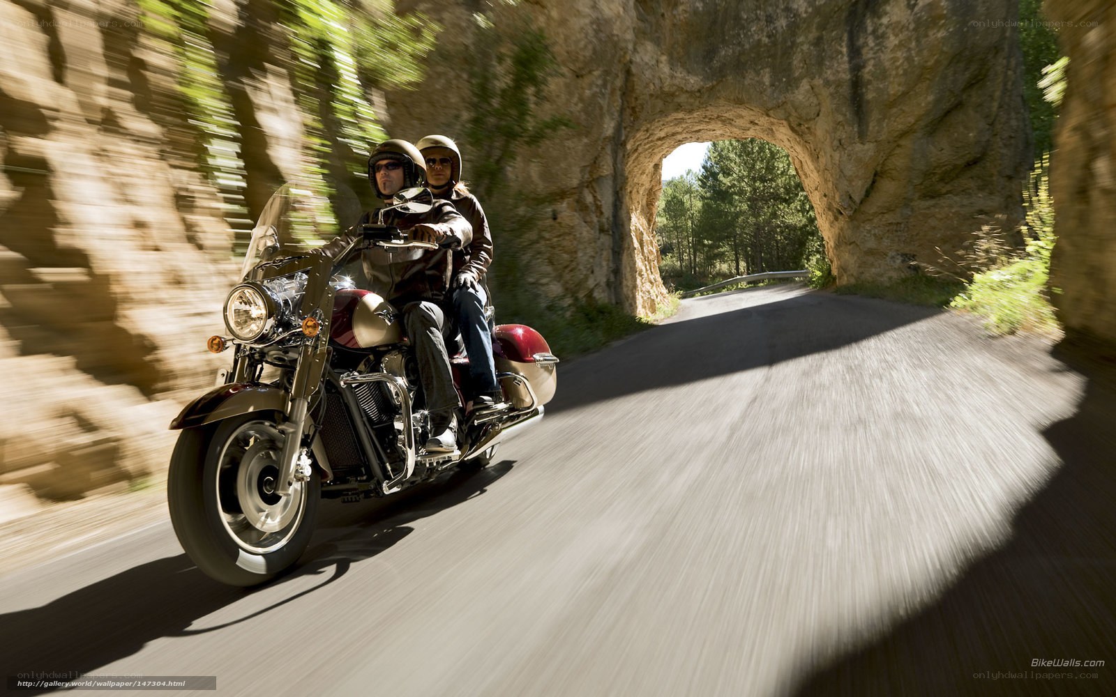 Couple riding motorcycle through tunnel