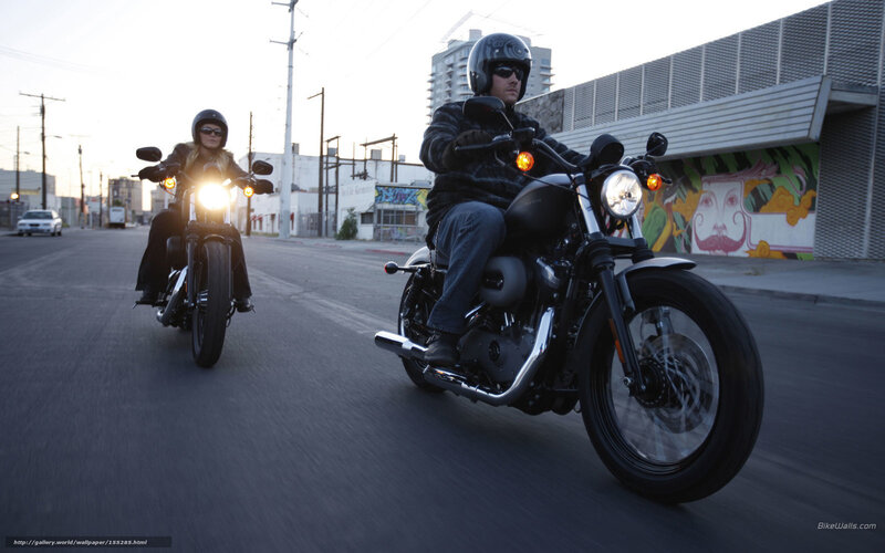 Couple riding motorcycles on city street