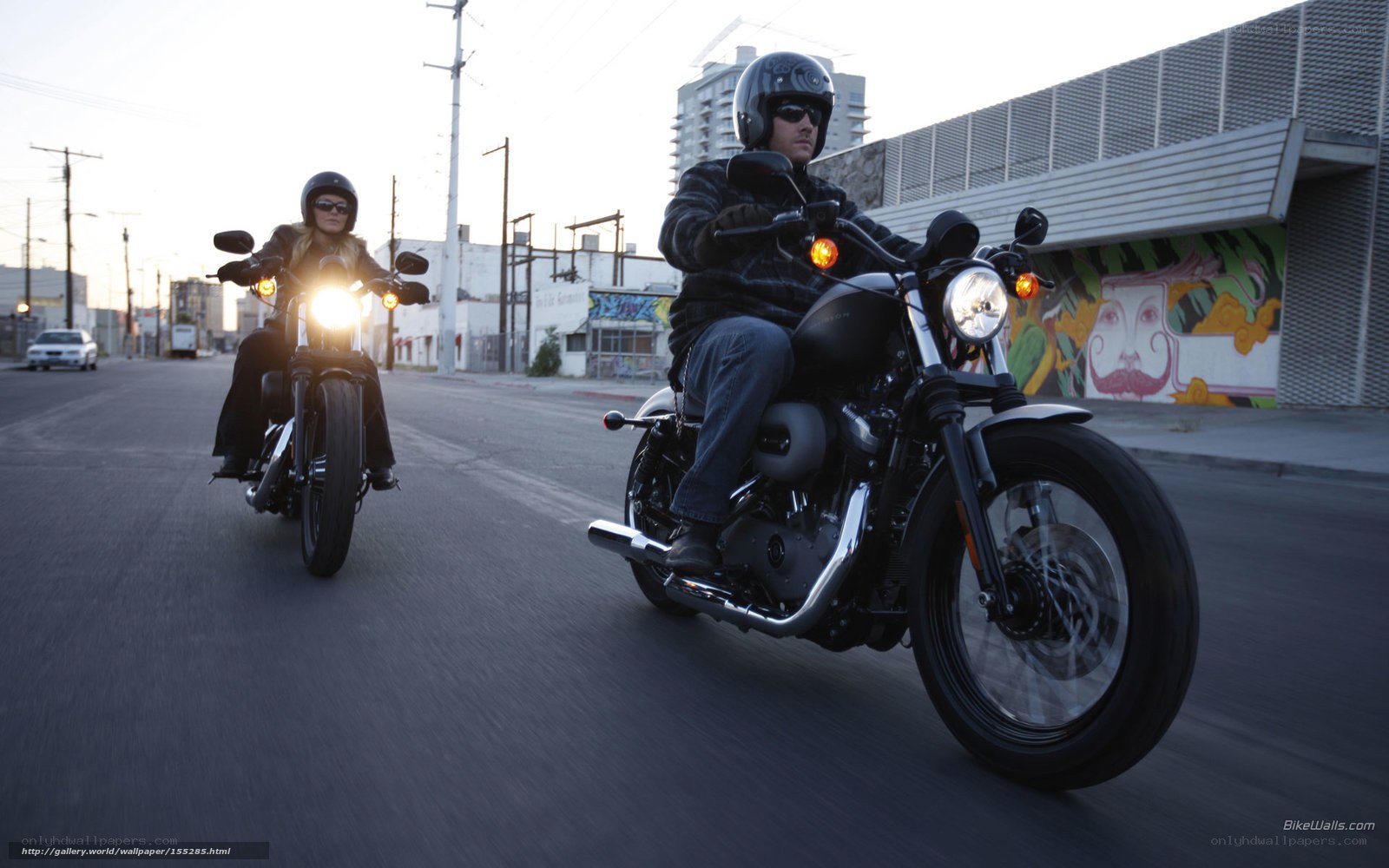Couple riding motorcycles on city street