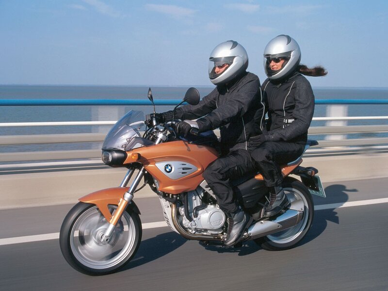 Couple riding orange motorcycle