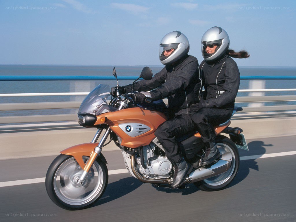 Couple riding orange motorcycle